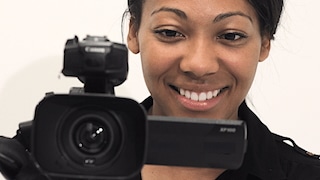 Black woman filming with video camera